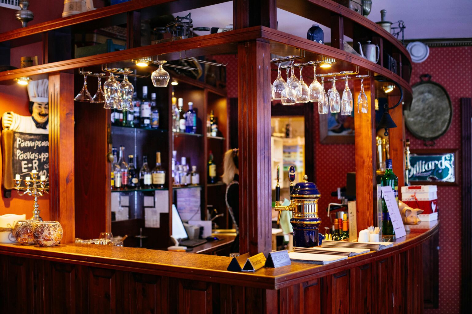Warm and inviting pub interior featuring a wooden bar and hanging wine glasses.